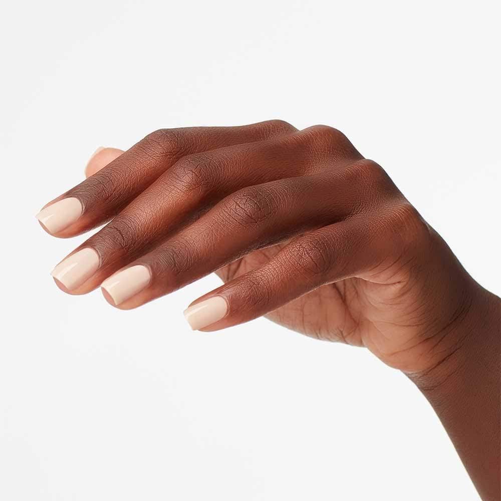 Main avec ongles vernis. Couleur de vernis à ongles beige. Peau claire.