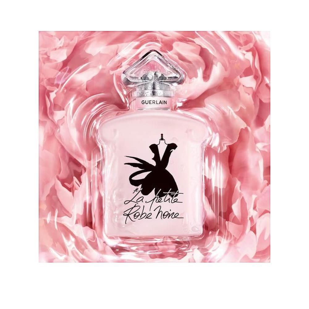Roze fles in verpakking met rozenblaadjes. Zilveren dop, opschrift Guerlain. La Petite Robe Noire.