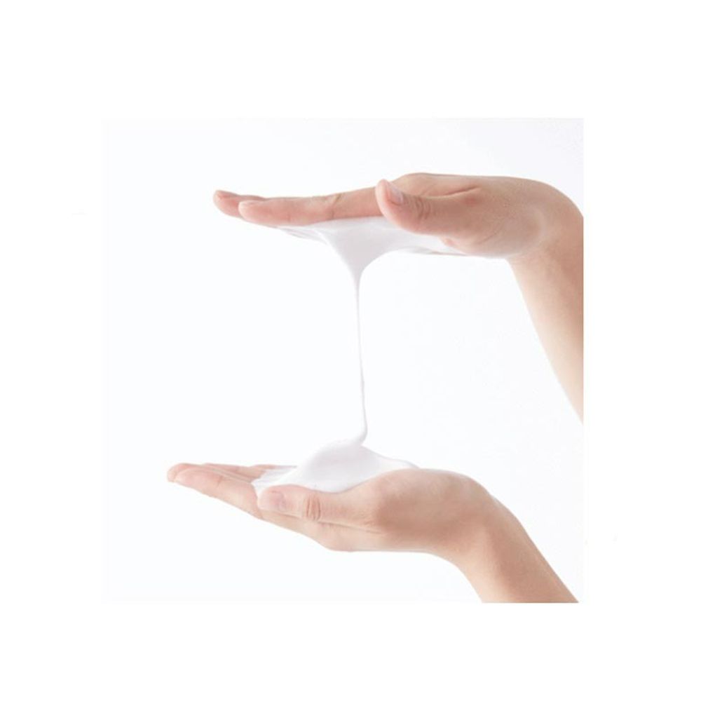 Handen houden witte schuim vast. Het schuim is romig en druppelt lichtjes naar beneden.