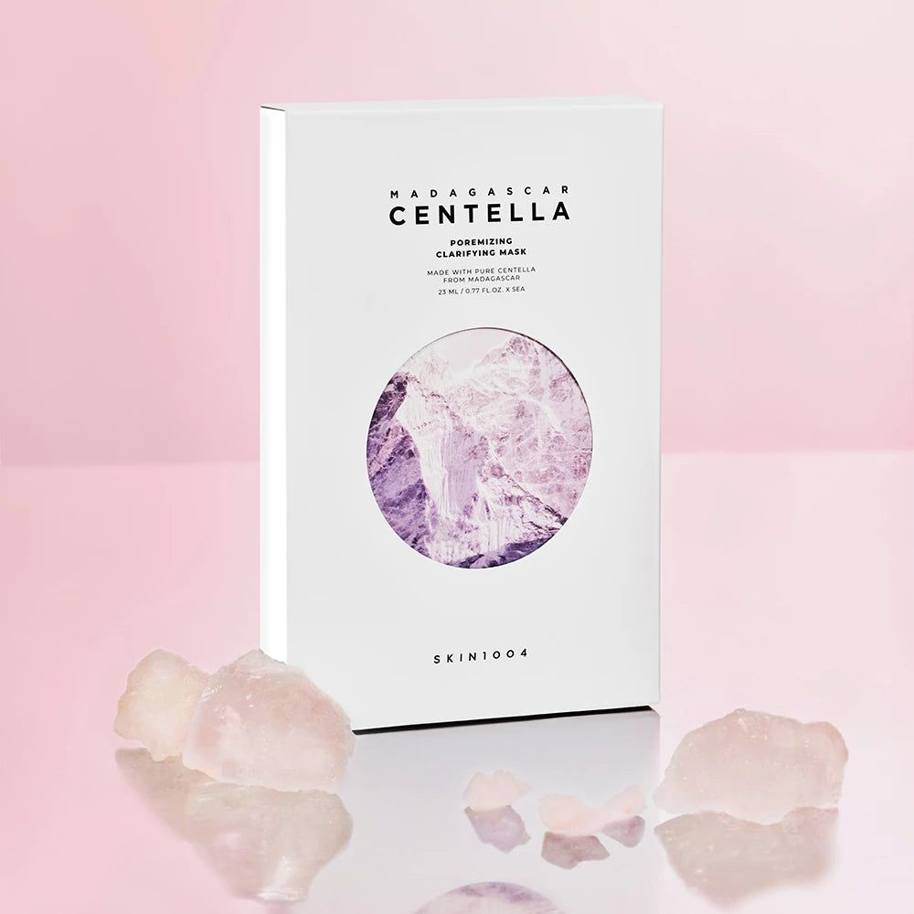 Boîte blanche avec masque facial. Texte: MADAGASCAR CENTELLA, Poremizing Clarifying Mask. Cristaux roses devant.