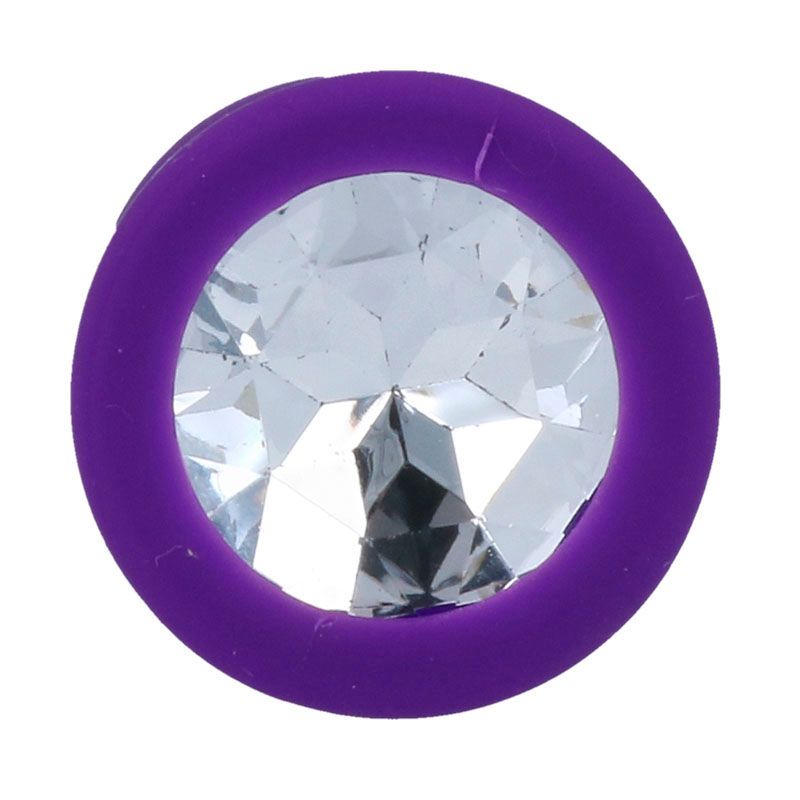 Gros plan de la bride d'un plug anal violet avec un grand cristal transparent.