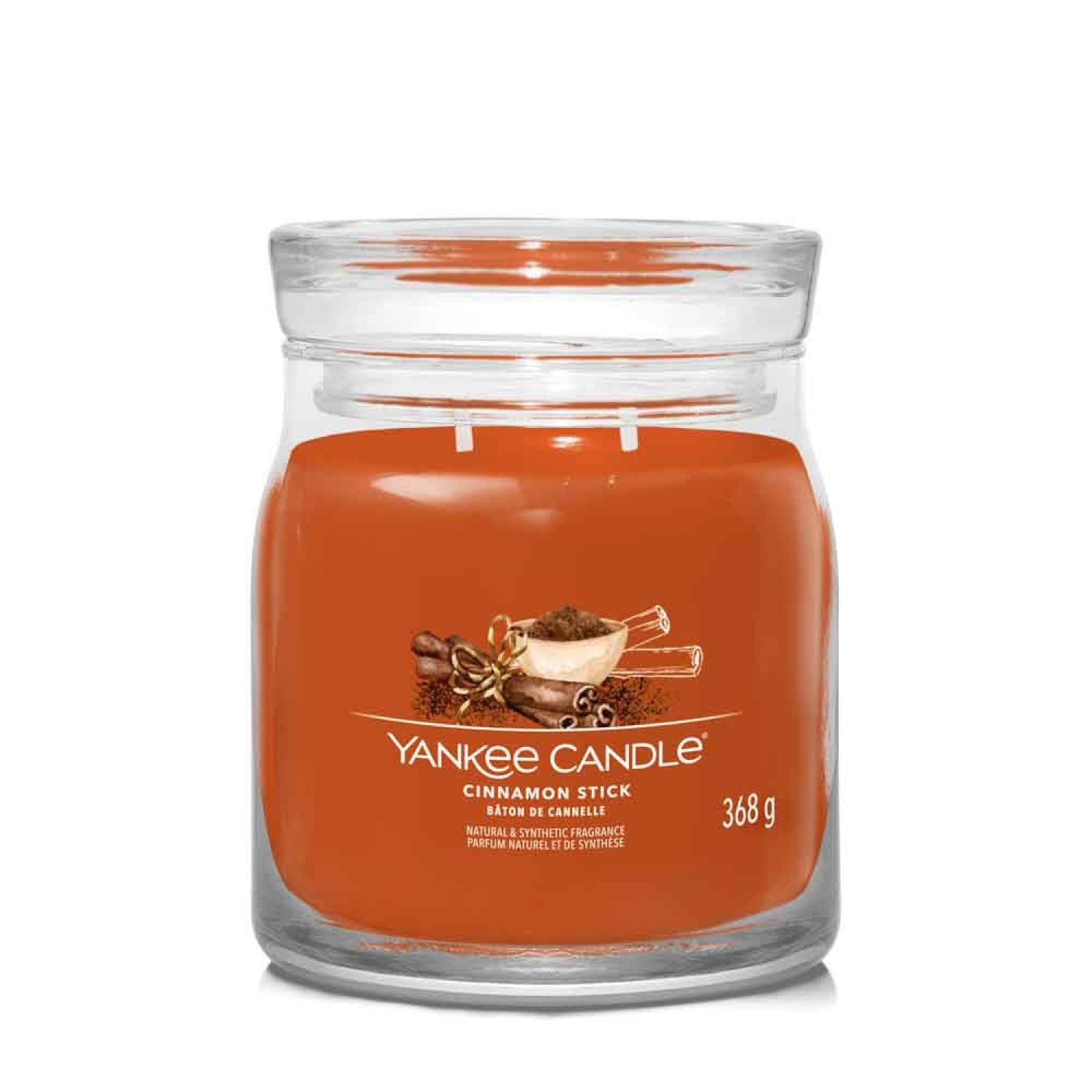Pot en verre avec cire orange. Inscription : Yankee Candle, Cinnamon Stick, 368 g. Illustration de bâtons de cannelle.