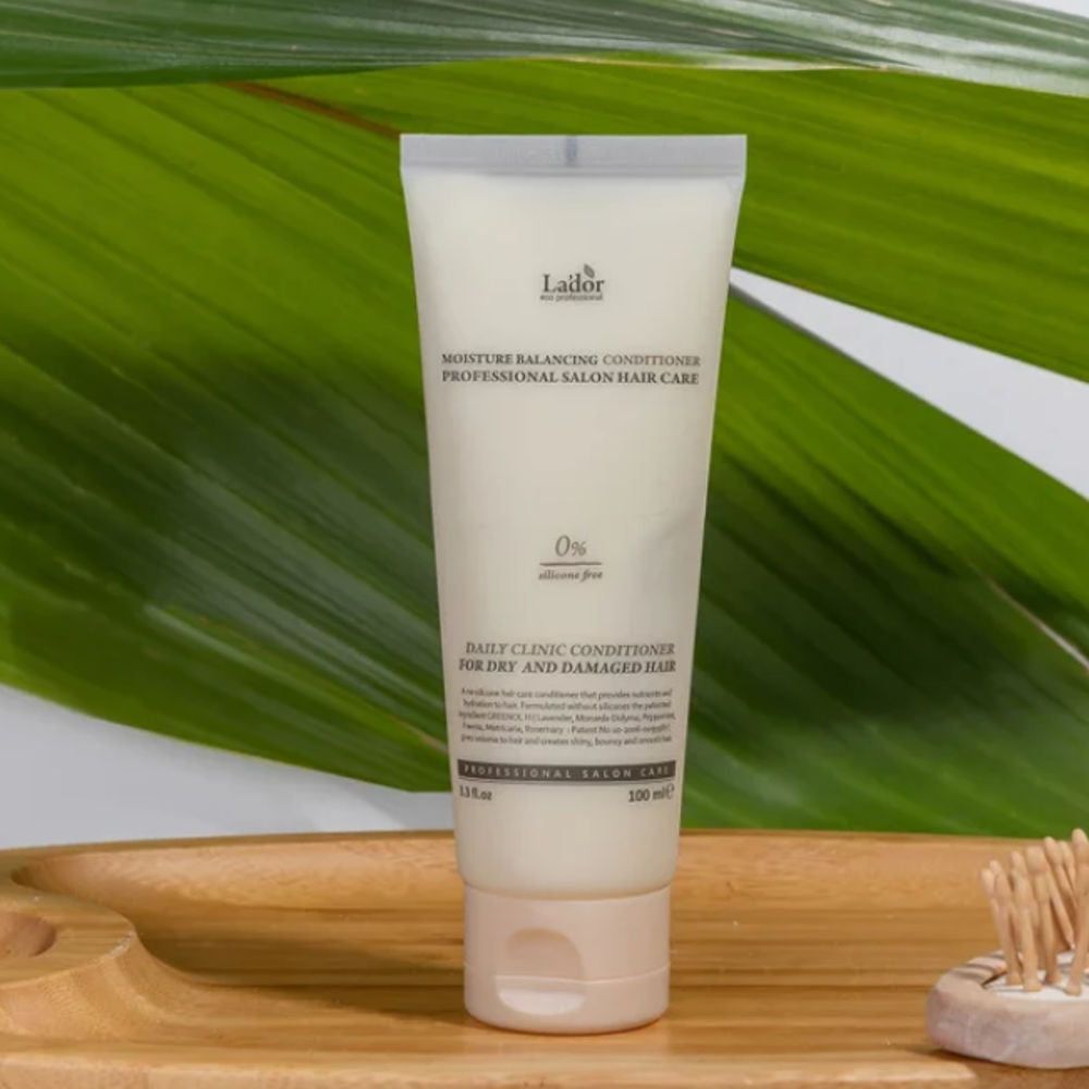 Witte tube conditioner voor droog en beschadigd haar, op een houten dienblad.