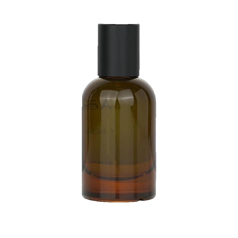 Flacon en verre brun avec bouchon noir. Logo Clarins sur l'étiquette. Parfum.