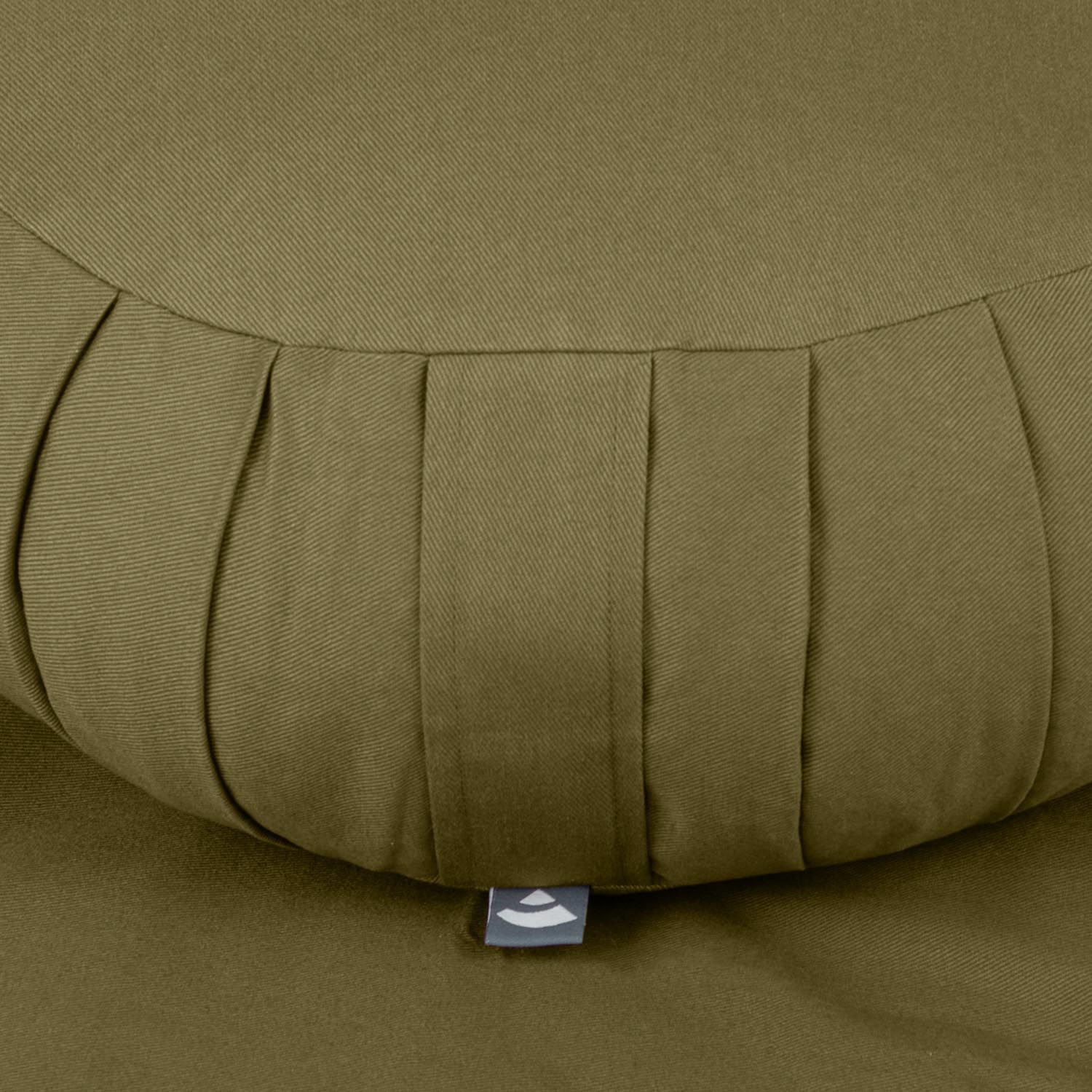 Gros plan du coussin Zafu. Tissu vert olive avec plis. Petite étiquette.