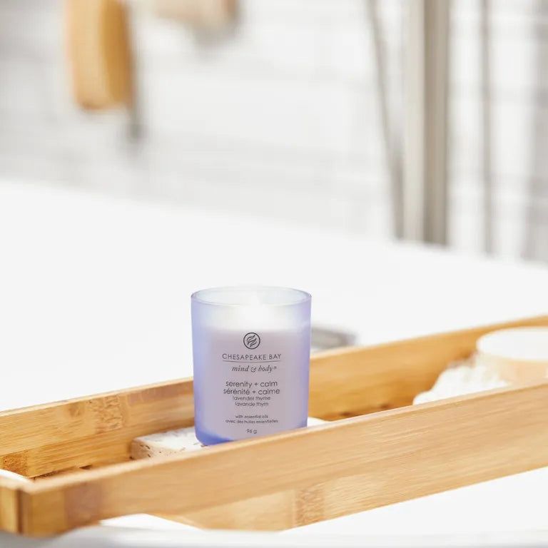 Bougie en verre bleu sur un plateau de bain. Inscription: Chesapeake Bay, mind & body, sérénité + calme, lavande thym, avec huiles essentielles, 96 g.