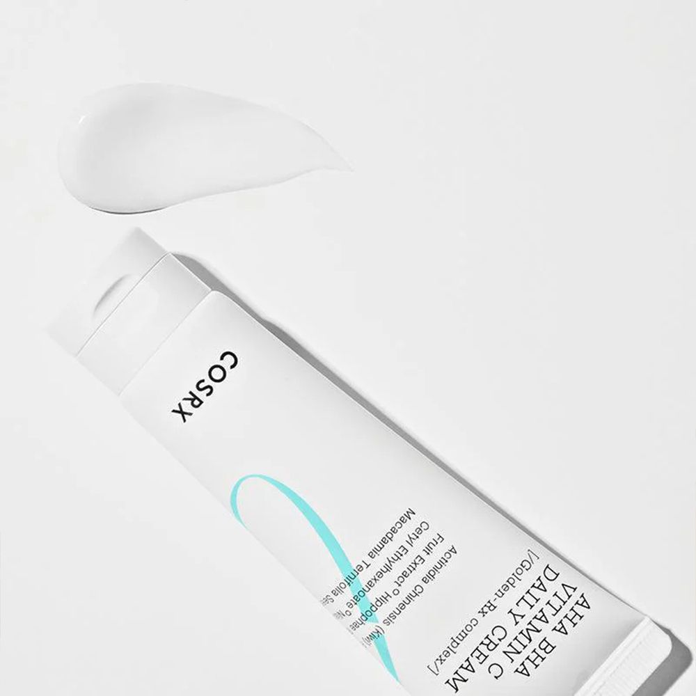 Tube COSRX AHA BHA Vitamin C Daily Cream avec un échantillon de crème à côté.