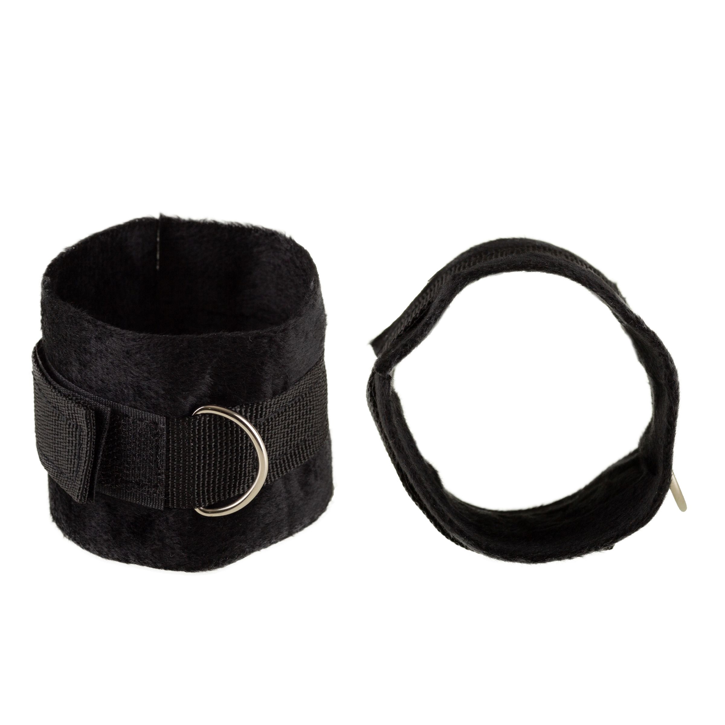 Twee zwarte handboeien. Eén manchet met klittenband en metalen ring. De andere met een band en metalen ring.