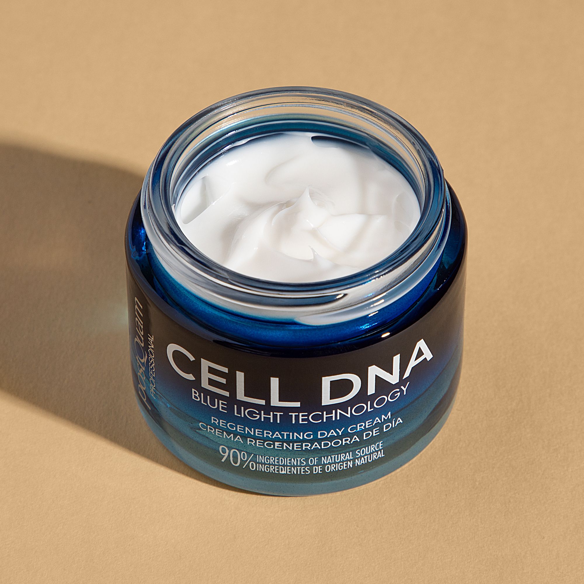Open Postquam Cell DNA dagcrème. Blauwe glazen pot met witte crème. Opschrift: CELL DNA, Blue Light Technology, Regenerating Day Cream.