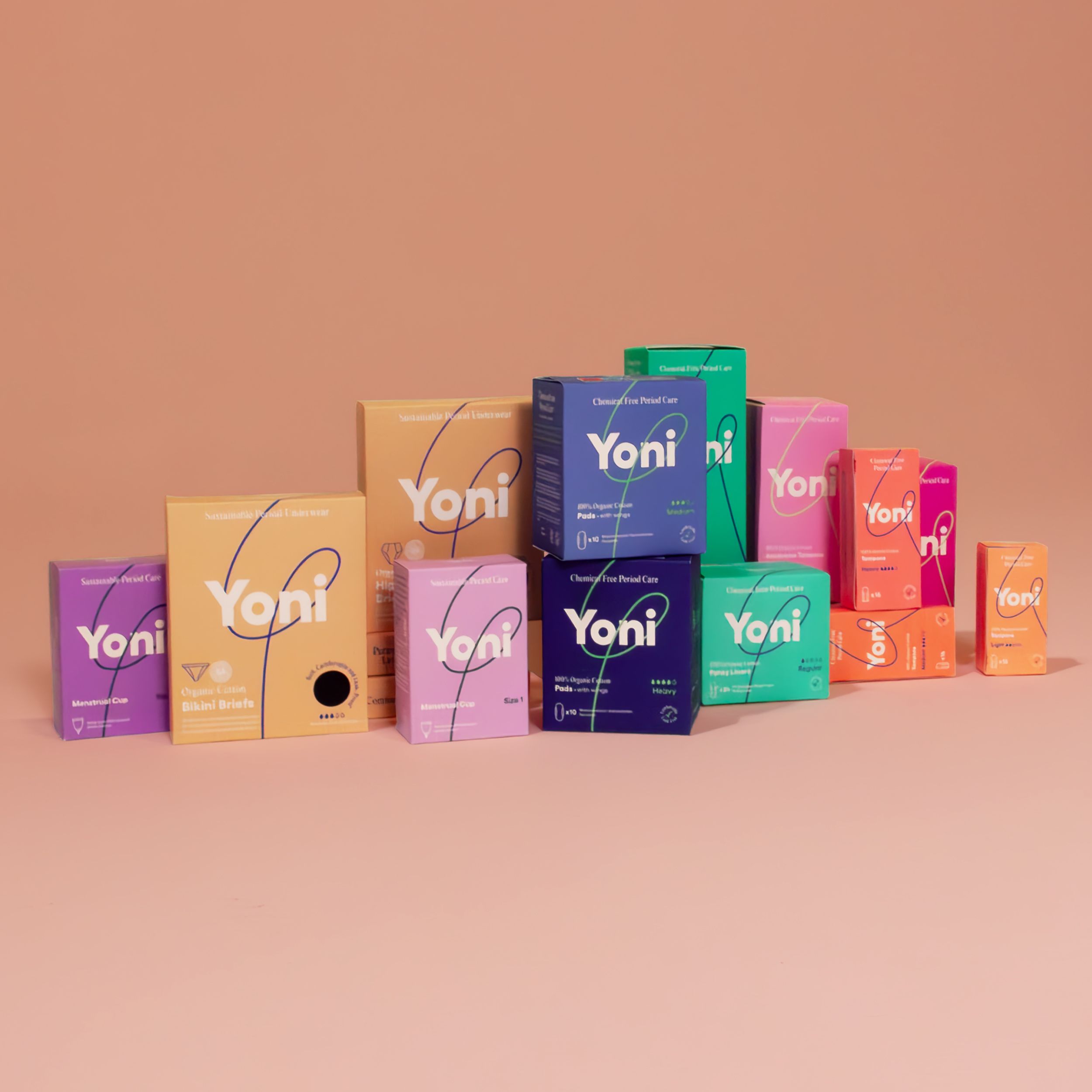 Verschillende dozen dameshygiëneproducten. Yoni-logo. Verschillende kleuren en maten. Opschriften: Pads, Tampons.