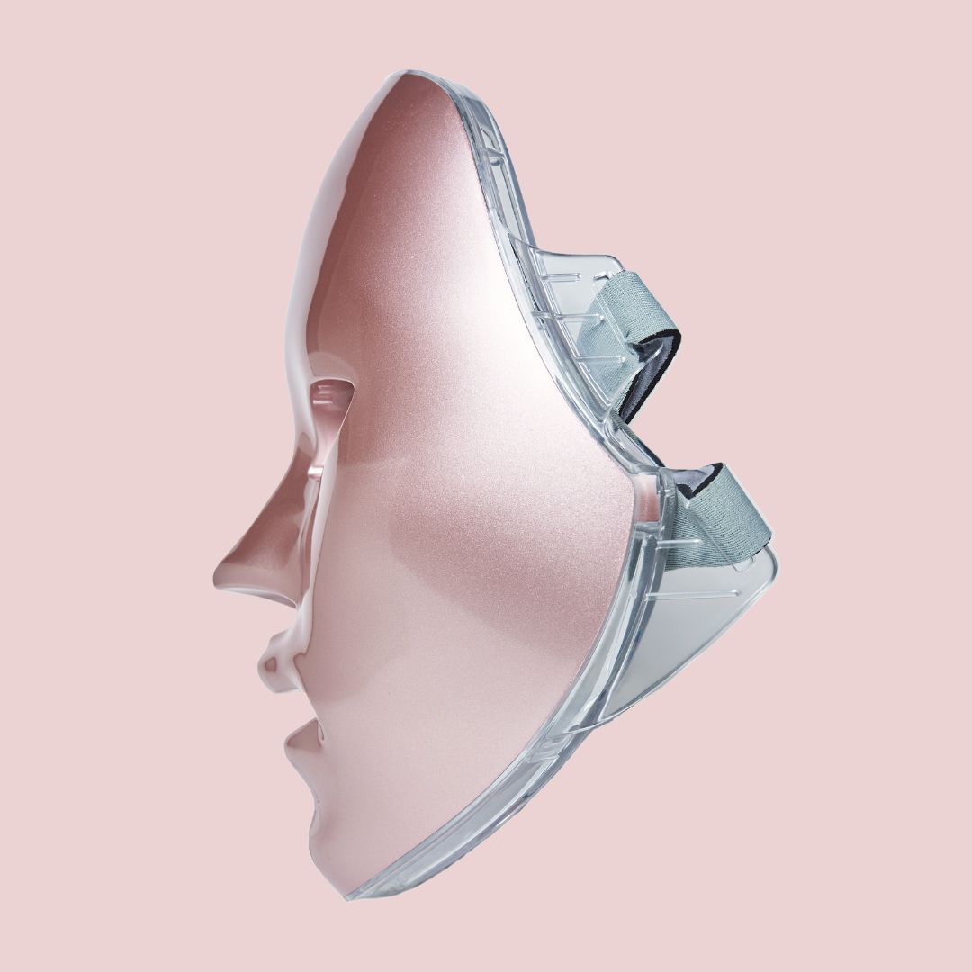 Roze LED-gezichtsmasker met transparante houders. Het masker heeft openingen voor ogen, neus en mond. Zijaanzicht.