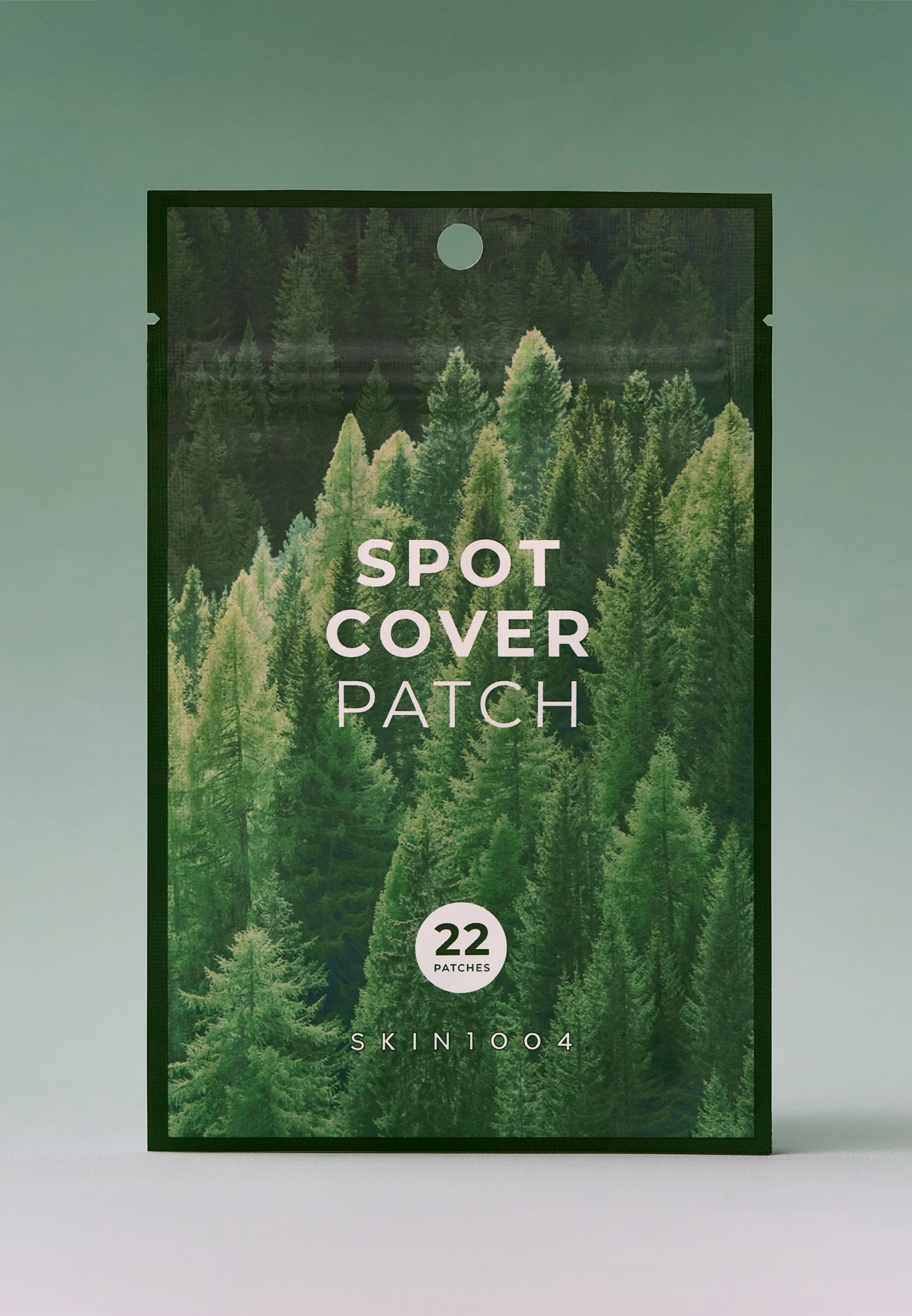 Zakje met 'SPOT COVER PATCH'. Bevat 22 patches. Merk: SKIN1004. Achtergrond: bos.