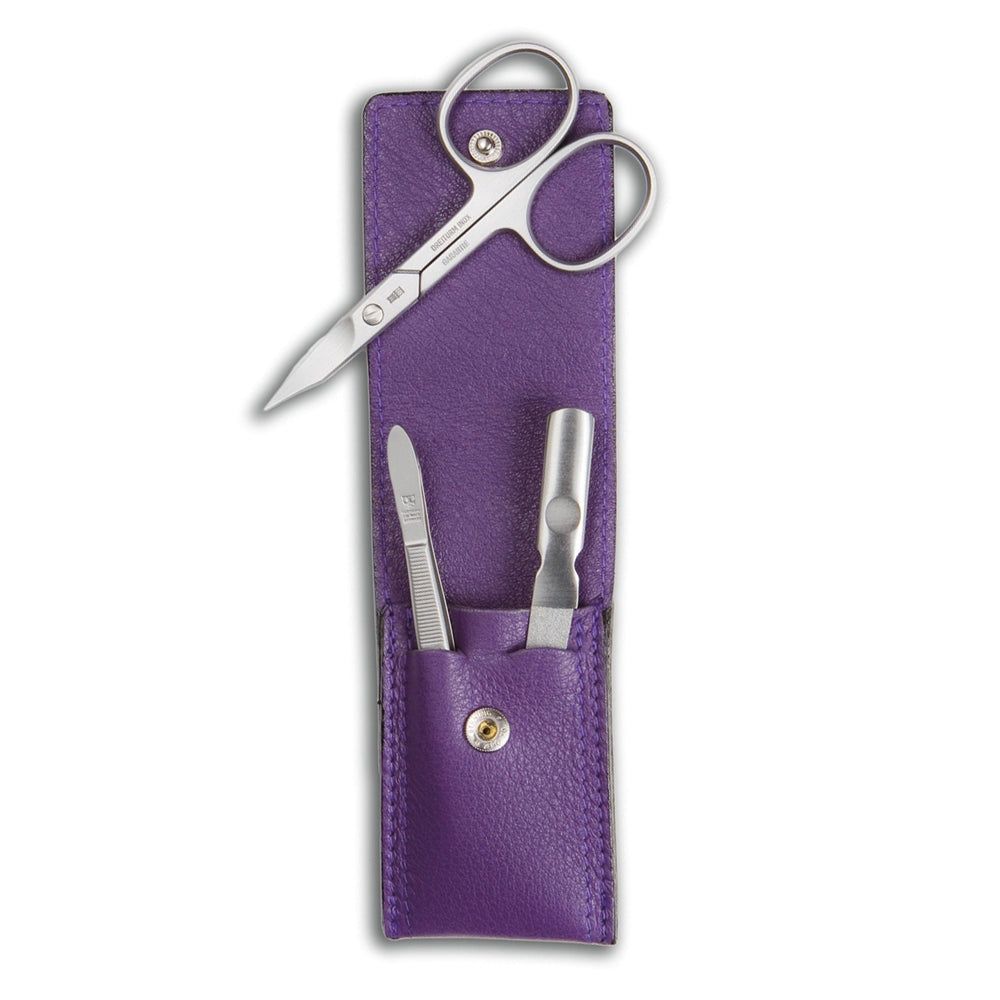 Étui de manucure en cuir violet, avec ciseaux, lime à ongles et coupe-ongles. Outils argentés. Fermeture à bouton.