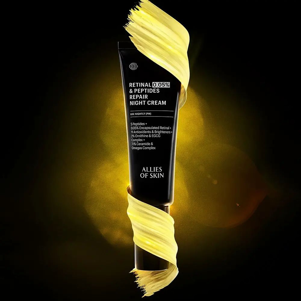 Tube noire avec inscription "Retinal 0.05% & Peptides Repair Night Cream" et "Allies of Skin", entourée de peinture jaune.