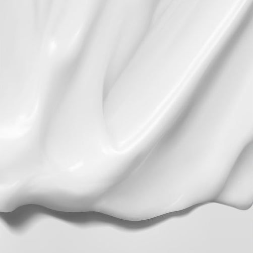 Gros plan abstrait de lotion blanche et crémeuse aux ondulations douces.