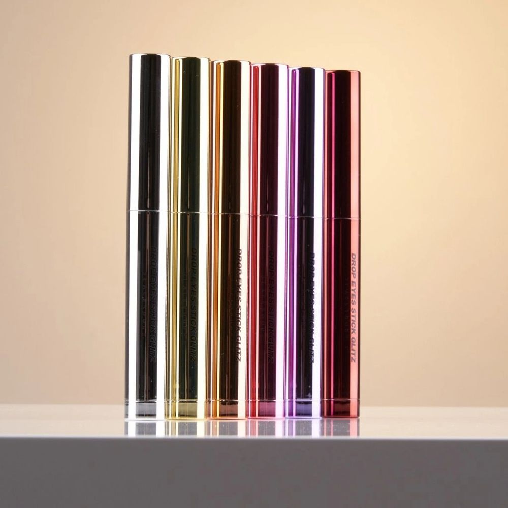 Rangée de crayons fard à paupières Drop Eyes Stick Glitz. Différentes couleurs. Nom du produit visible sur les crayons.