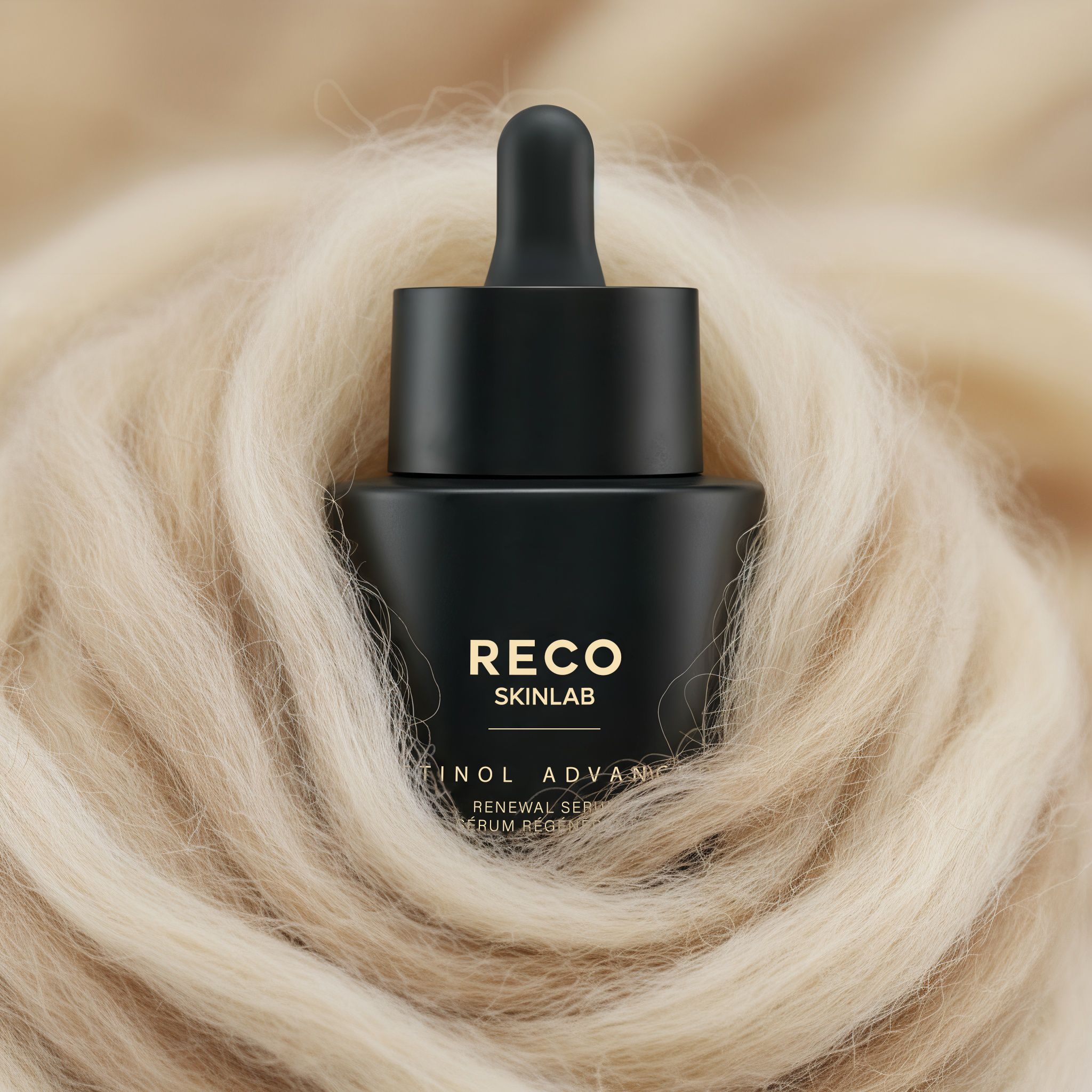 Flacon de sérum noir avec pipette sur fond clair et duveteux. Inscription: RECO SKINLAB, Retinol Advanced.