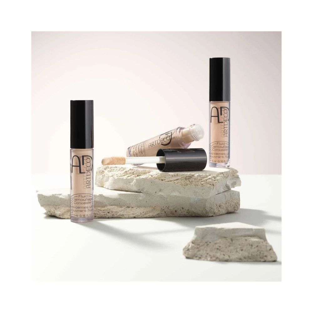 ARTDECO Concealer Fluid Camouflage, flacons et applicateur disposés sur des pierres.