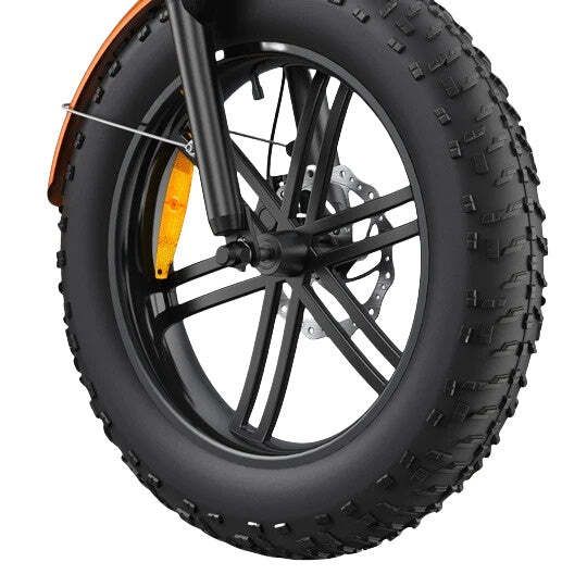 Gros plan sur un pneu de vélo noir. Jante noire avec rayons, disque de frein et garde-boue orange.