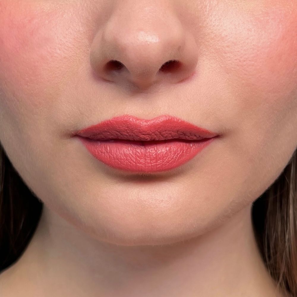 Close-up van lippen met roze lippenstift. Huidkleurige achtergrond.