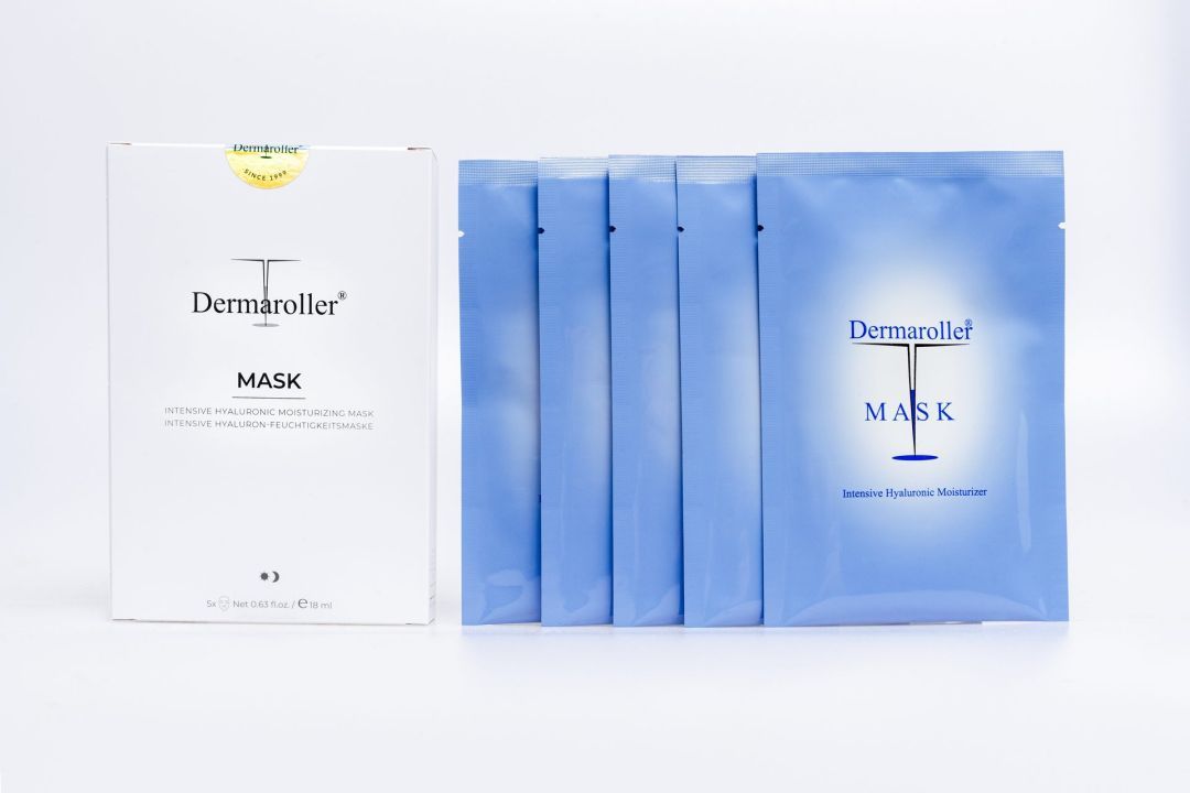 Emballage blanc pour masque Dermaroller à côté de cinq emballages bleus individuels.
