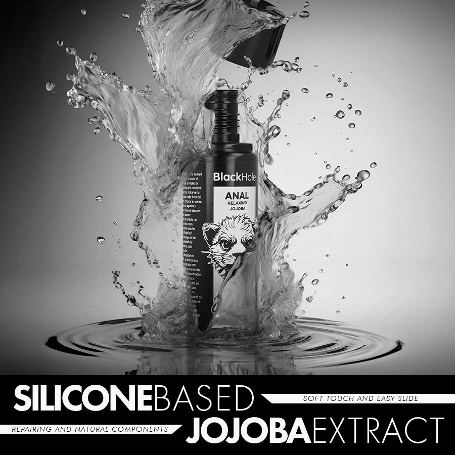 Un flacon de 'Black Hole ANAL Relaxing Jojoba' avec des éclaboussures d'eau. Texte: Silicone Based Jojoba Extract.