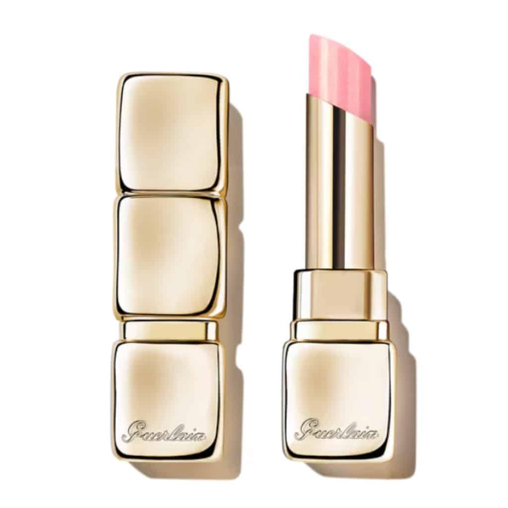Bâton de baume à lèvres doré, ouvert et fermé. Le bâton ouvert révèle un rouge à lèvres rose. Marque Guerlain.