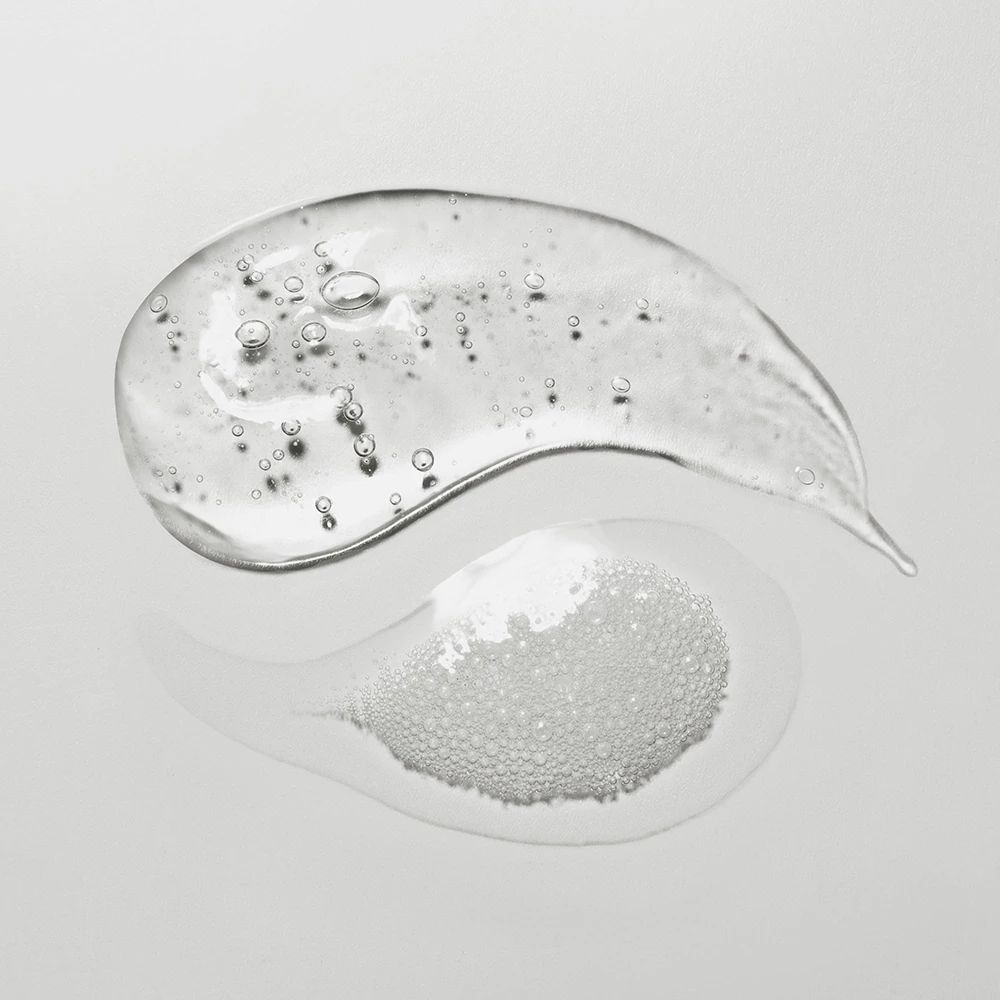 Twee druppels gel. Een druppel met bellen. Op lichte achtergrond.