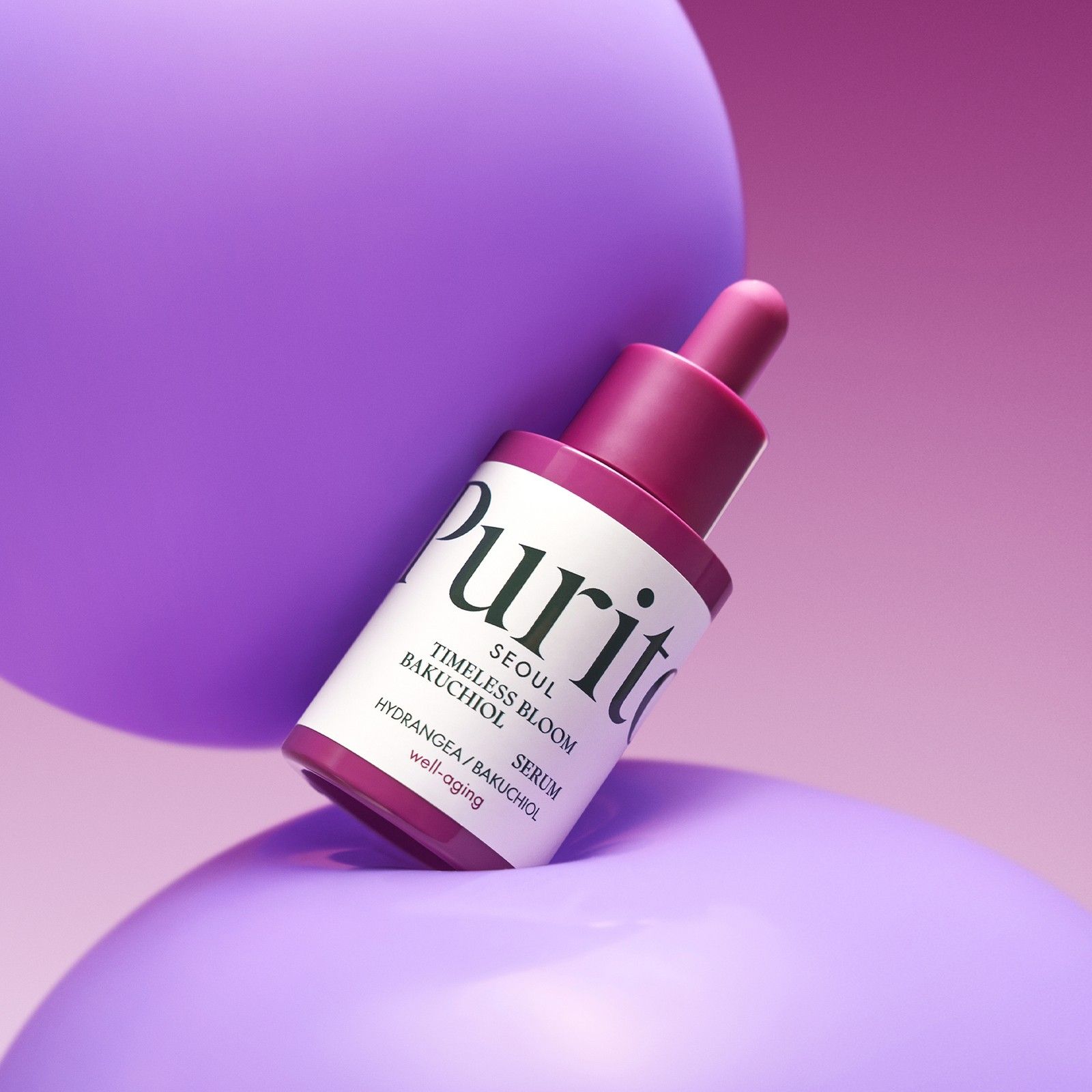 Flacon avec pipette, sérum Purito Bakuchiol, sur des sphères violettes.