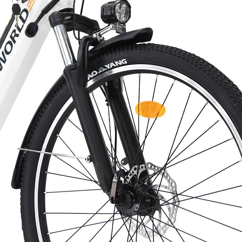 Close-up van het voorwiel van een witte elektrische fiets. Zwarte vork, koplamp en remschijf.