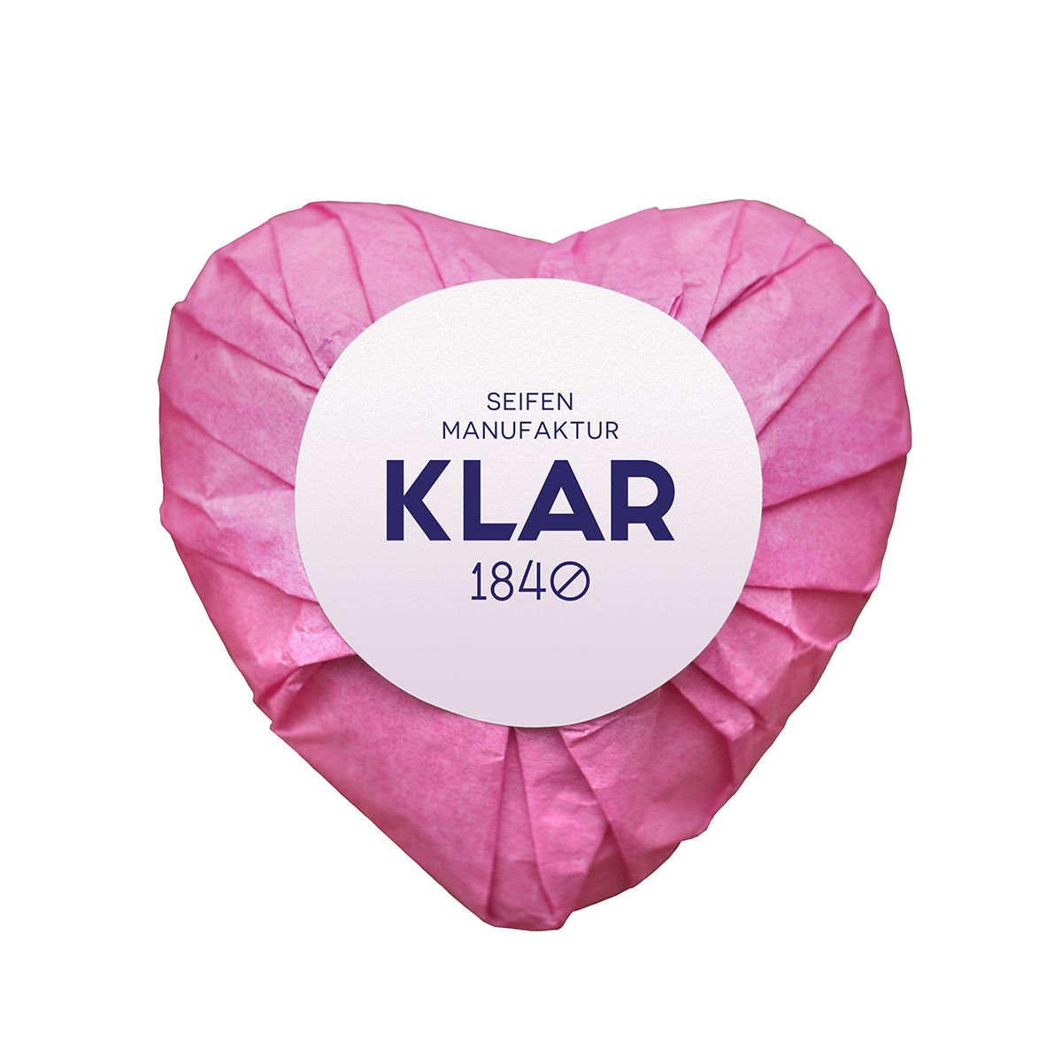 Hartvormige zeep verpakt in roze papier. Wit etiket met "KLAR" en "1840".