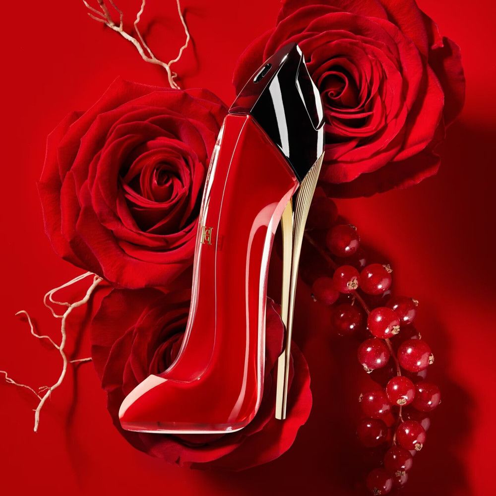 Rode high heel fles op rode achtergrond met rozen en bessen. Gouden zool, zwarte dop.