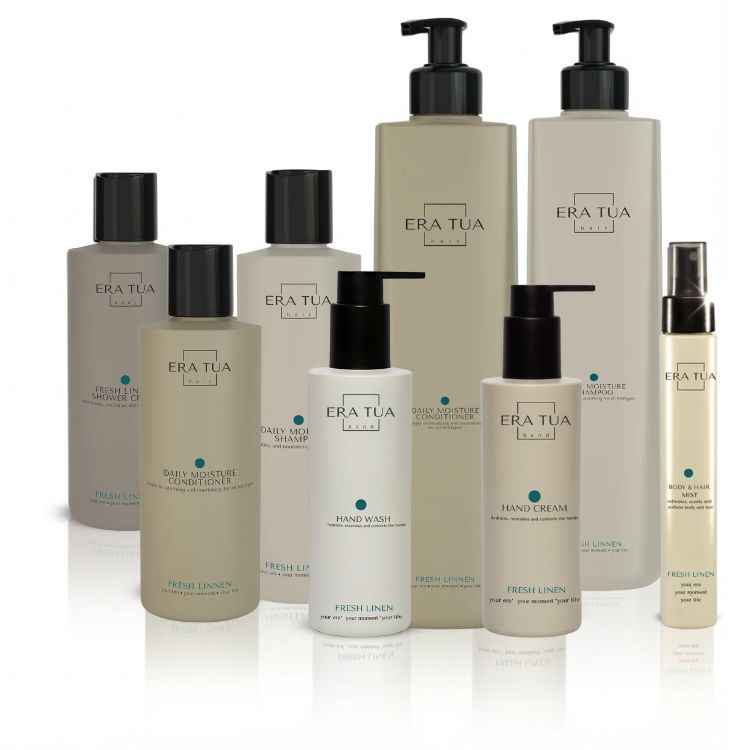 Divers produits "ERA TUA". Flacons et distributeurs. Texte : "Fresh Linen", "Daily Moisture Conditioner", "Hand Wash", "Hand Cream", "Shampoo".