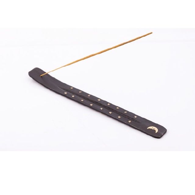 Porte-encens marron foncé avec étoiles et symbole de lune. Un bâton d'encens doré est inséré.