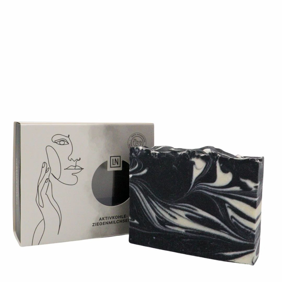 Zeep en doos. Zeep met wervelpatroon. Doos met venster, opschrift: Actieve kool, geitenmelkzeep, LN-logo, 100% handgemaakt.