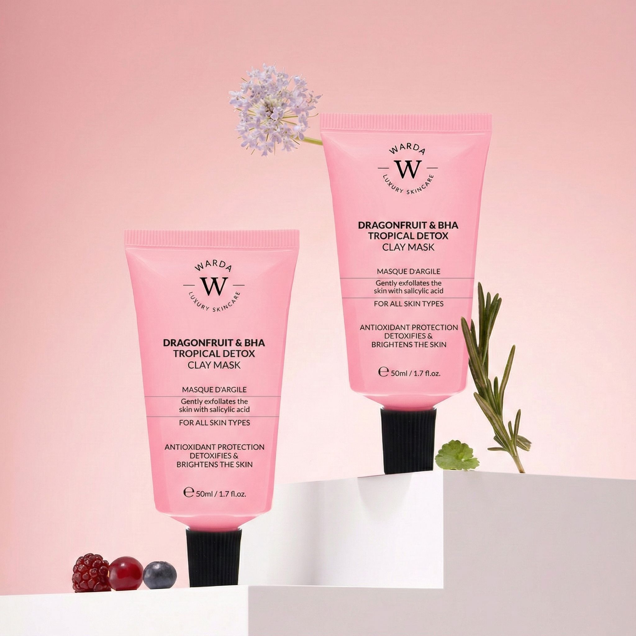 Deux tubes roses avec bouchon noir. Texte: Dragonfruit & BHA Tropical Detox Clay Mask, Warda Luxury Skincare. Sur un piédestal blanc.