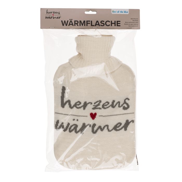 Warmwaterkruik in plastic verpakking. Crèmekleurige gebreide hoes met opschrift 'Herzenswärmer'. Productnaam 'WÄRMFLASCHE'.