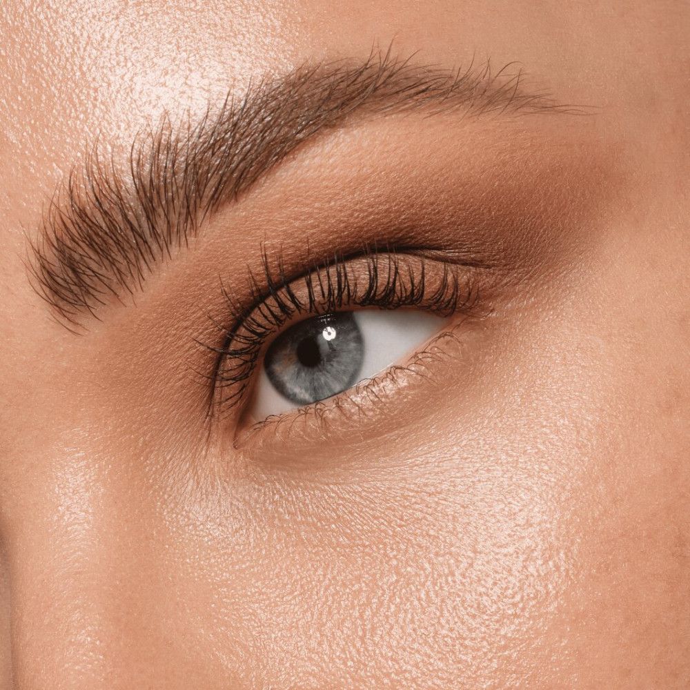 Close-up van een oog met oogschaduw. Blauw oog, bruine wenkbrauwen.