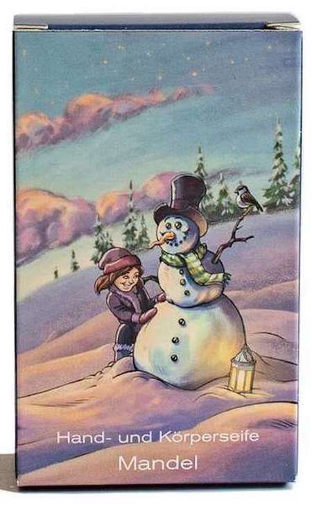 Doosje met winterlandschap, sneeuwman en kind. Tekst: Hand- und Körperseife Mandel.