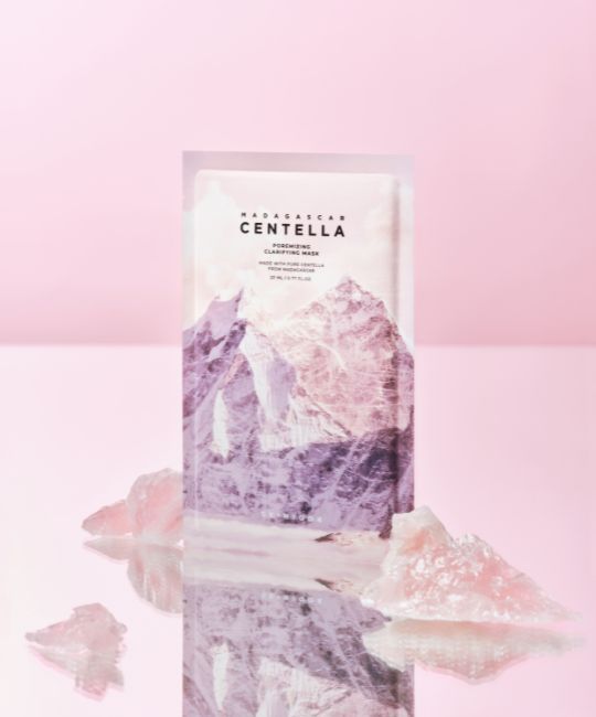 Masque facial avec motif montagne. Texte: MADAGASCAR CENTELLA, Poremizing Clarifying Mask. Cristaux roses devant.