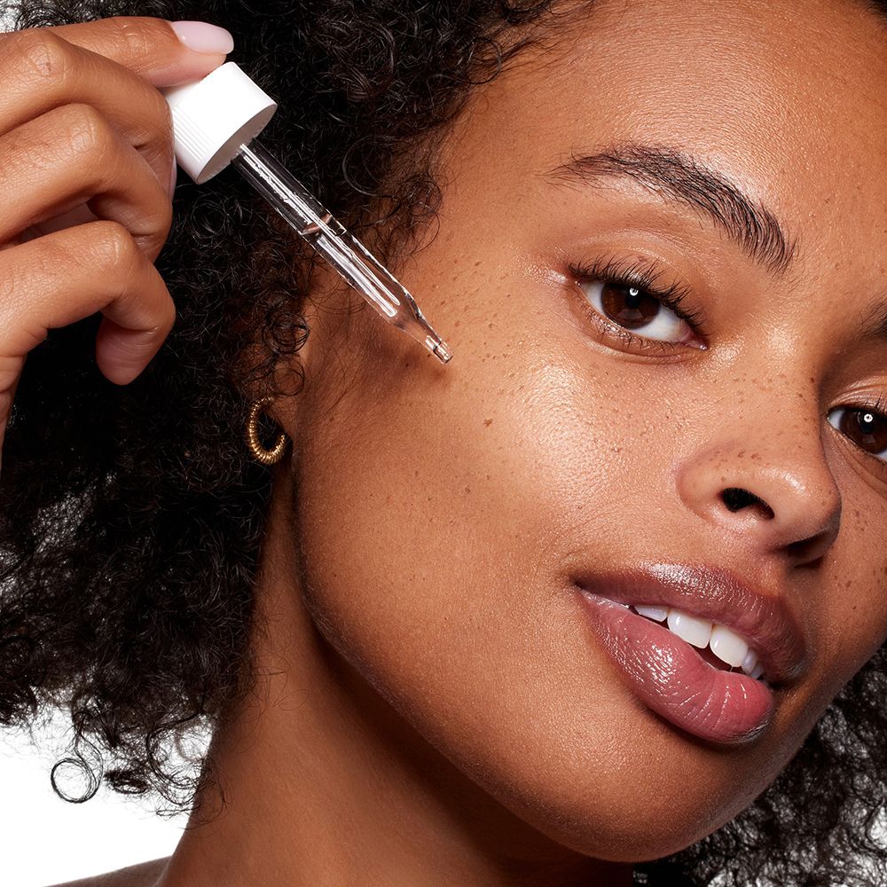 Close-up van een vrouw die serum aanbrengt met een pipet. Huidverzorgingsproduct.