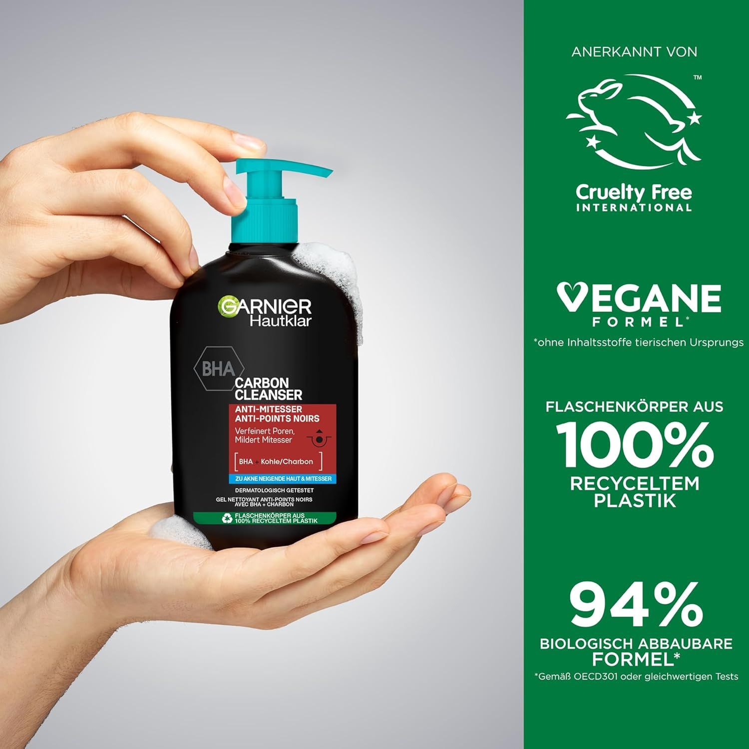 Mains tenant un flacon noir Garnier Hautklar Waschgel. BHA Carbon Cleanser. Pompe turquoise. Mousse.