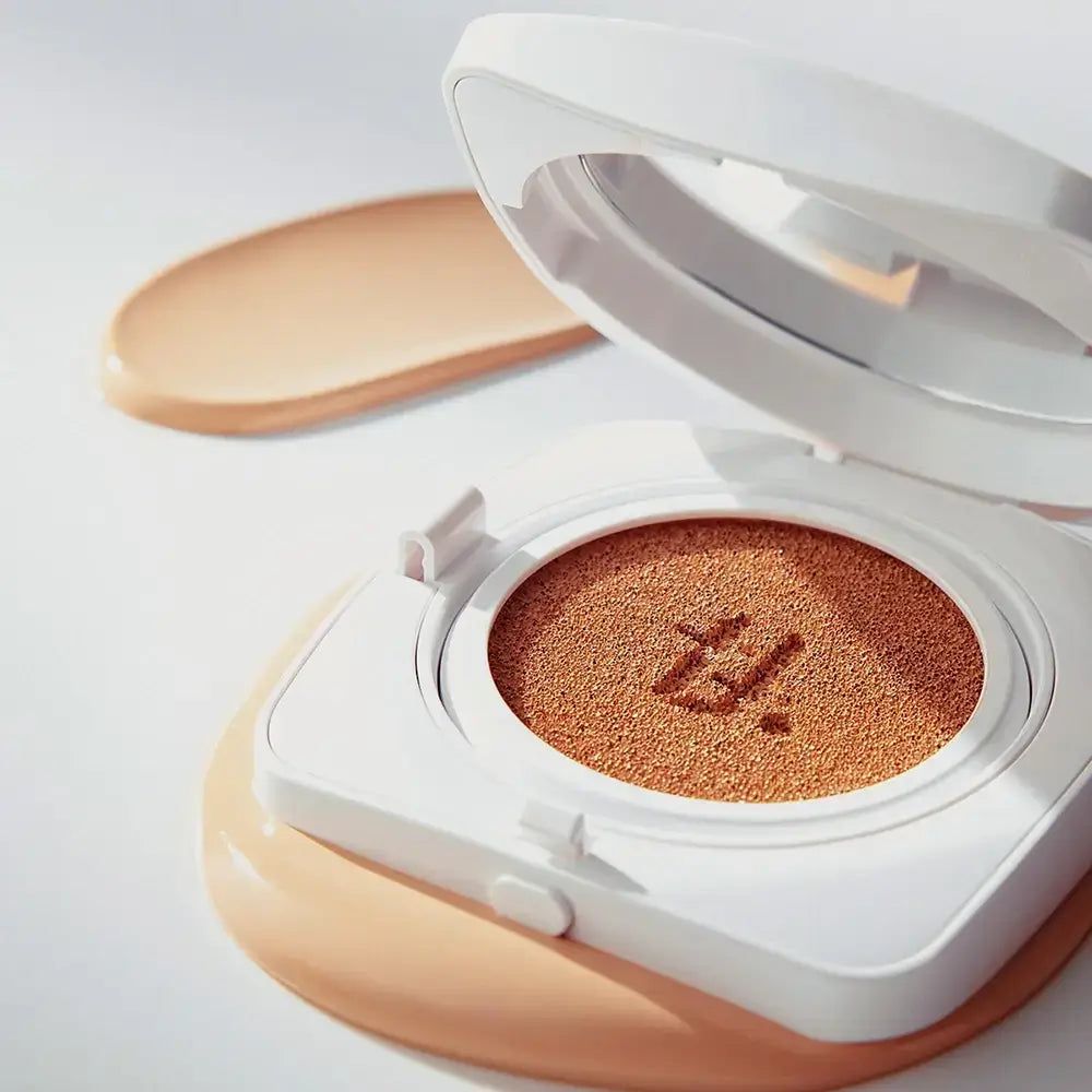 Witte compacte make-up houder met spiegel. Geopend, met spons en make-up. Daarnaast een make-up veeg.