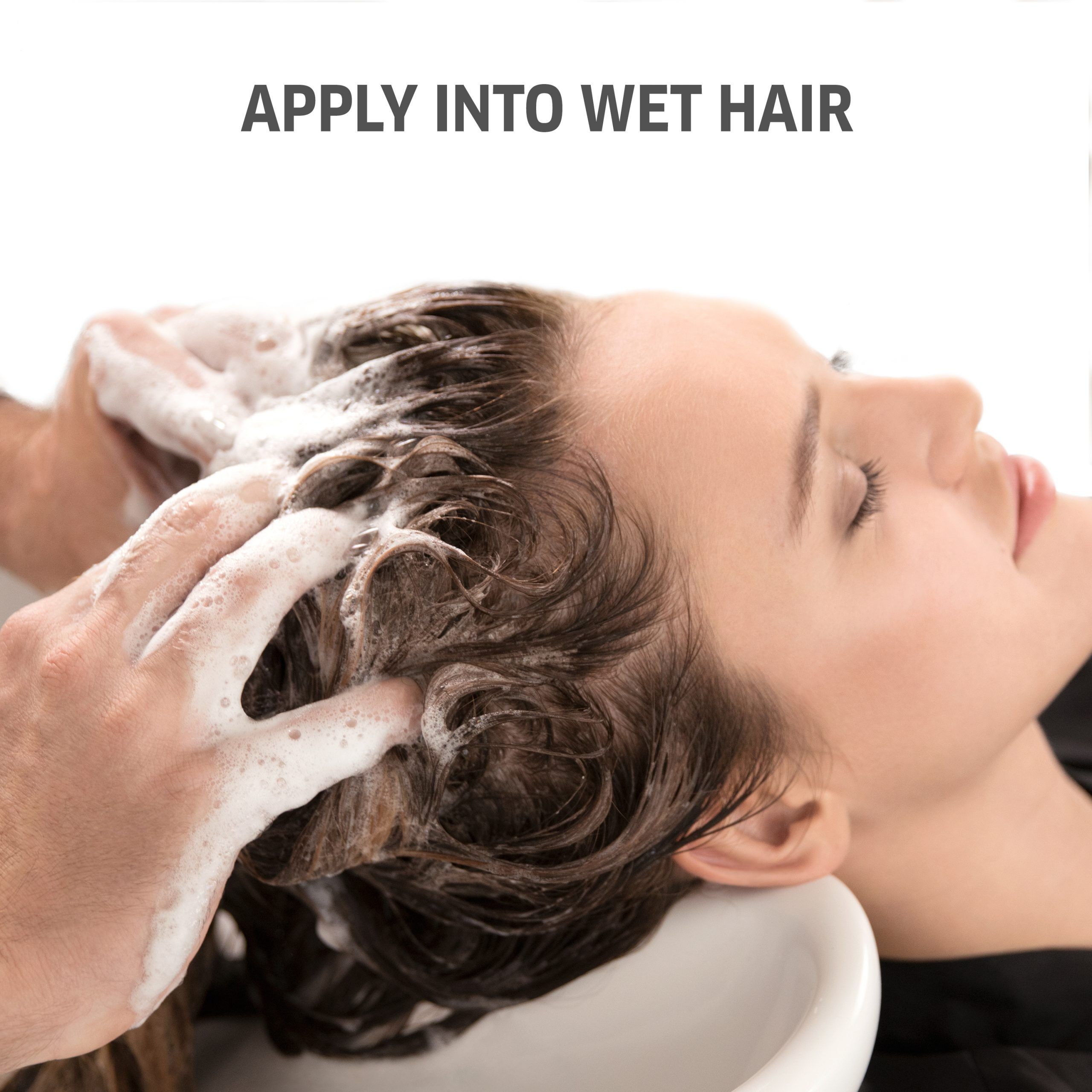 Personne lave les cheveux d'une femme. Texte : APPLY INTO WET HAIR. Femme dans un lavabo. Mousse sur les cheveux.