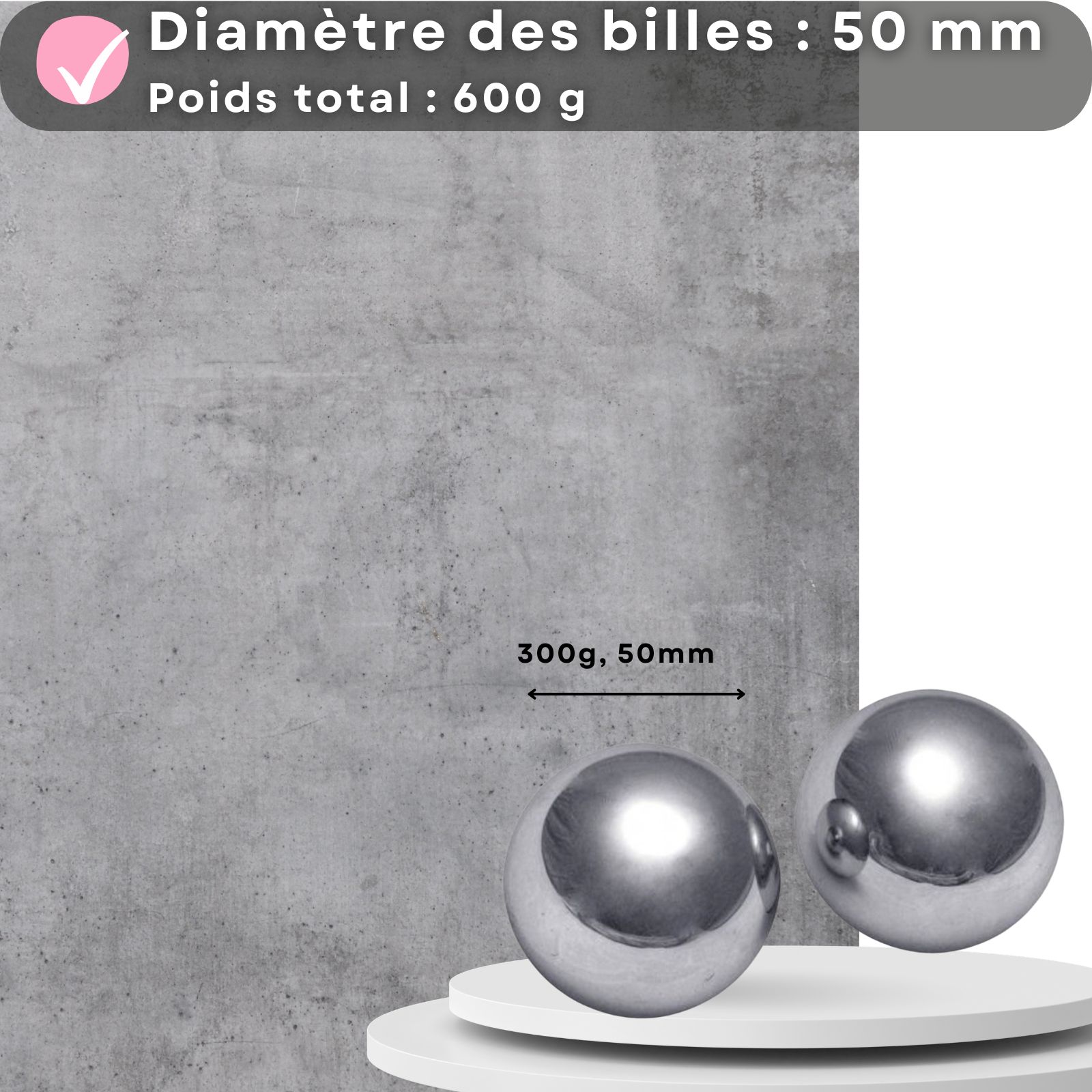Deux boules métalliques sur une plateforme. Texte : 50mm, 600g. Fond : mur en béton.