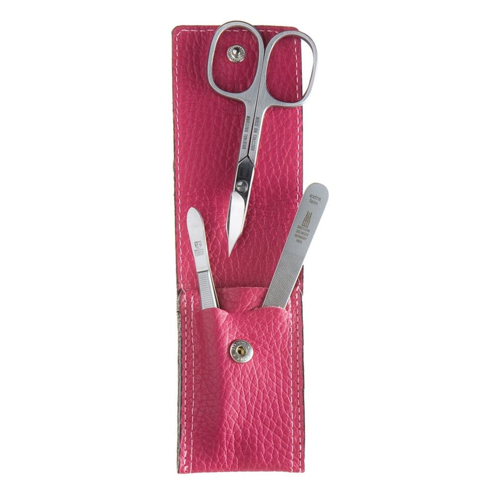 Roze manicure-etui, leer, met schaar, nagelvijl en cuticle pusher. Metalen onderdelen. Sluiting met drukknop.