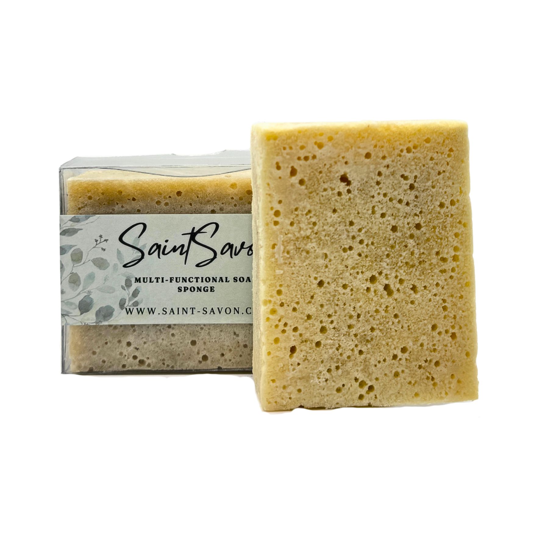 Éponges rectangulaires, une dans l'emballage, une à côté. L'étiquette indique "Saint Savon", "Multi-Functional Soap Sponge" et le site web.
