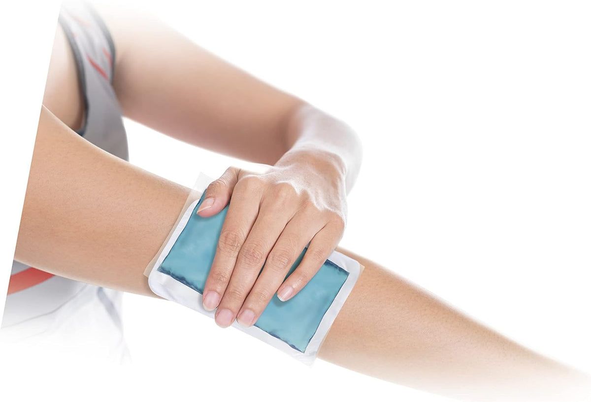 Personne tenant une compresse froide et chaude bleue sur le bras. Produit rectangulaire dans une enveloppe blanche.