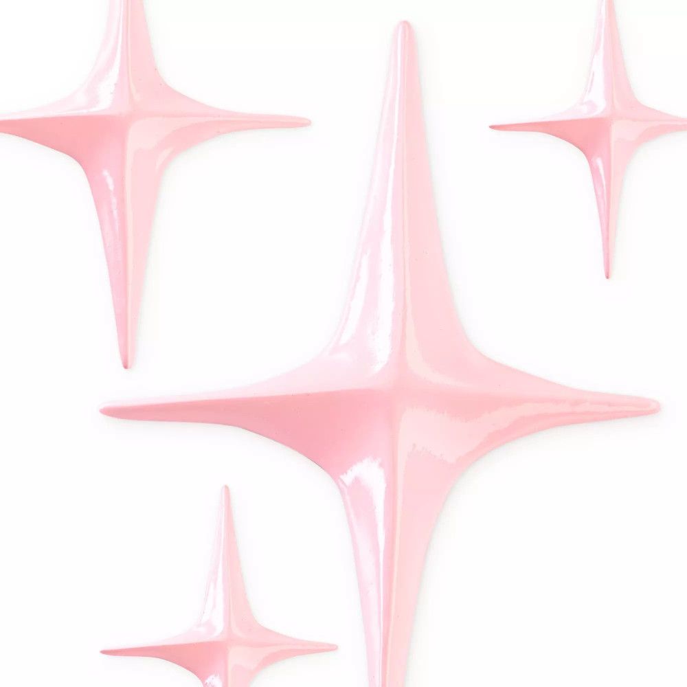 Quatre objets en forme d'étoile de couleur rose. Surface brillante. Sur fond blanc.