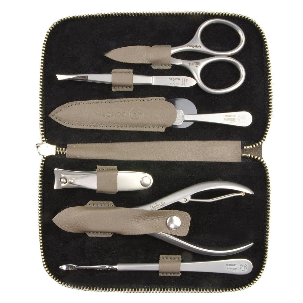 Beige etui met manicure set. Bevat schaar, pincet, nagelvijl, nagelknipper en andere tools. Zwarte binnenkant.